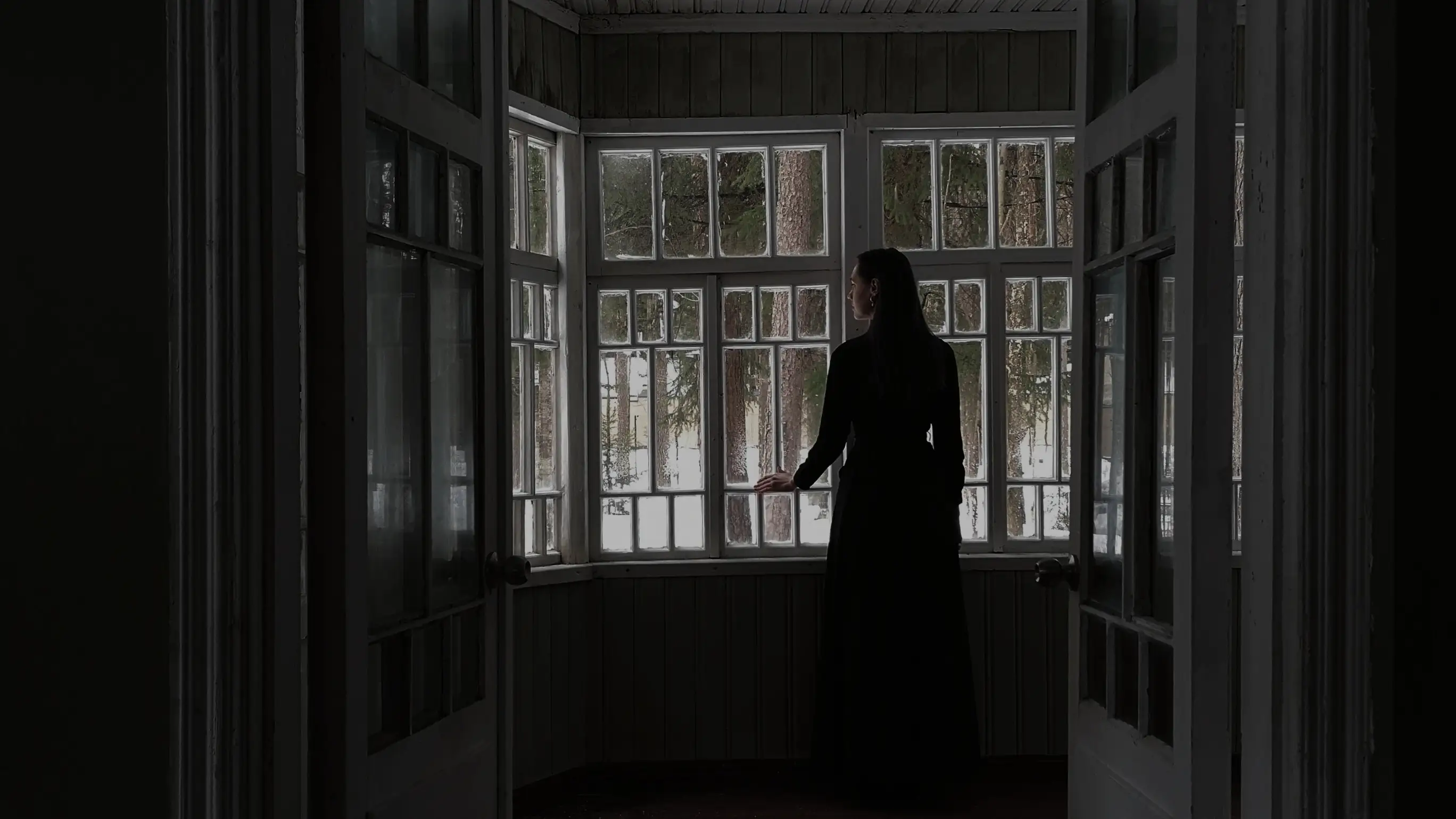 Una mujer mira por la ventana