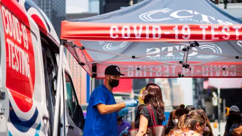 Mujer haciéndose un test de covid-19 en Times Square, Nueva York Mujer haciéndose un test de covid-19 en Times Square, Nueva York