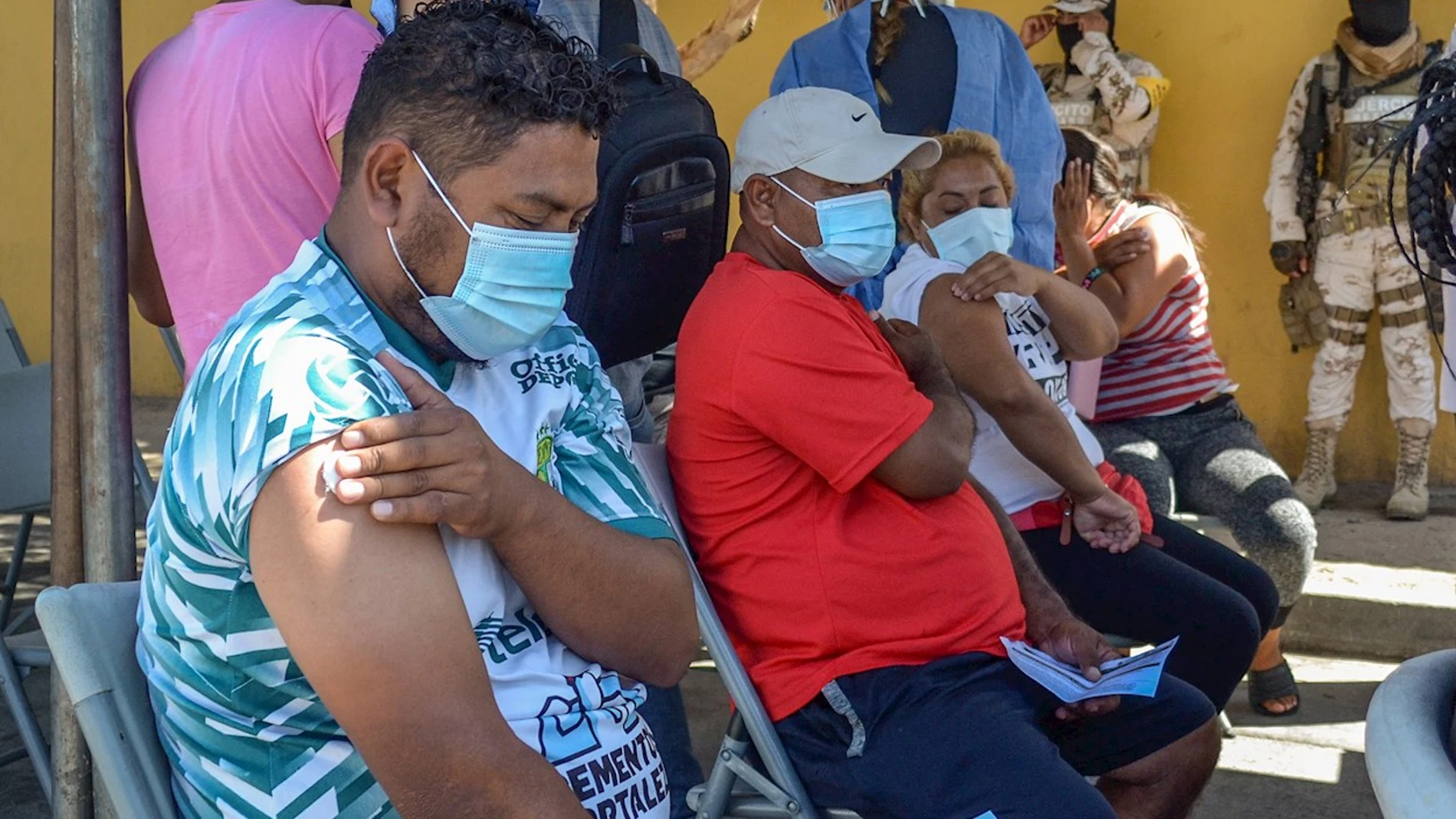  Varias personas migrantes reposan tras ser vacunados contra la Covid-19 hoy, en Tijuana, estado de Baja California (México). Migrantes de Centroamérica, Colombia, Haití y de otras países que acampan en el cruce fronterizo de El Chaparral en la ciudad mexicana de Tijuana, recibieron este martes su primera dosis de la vacuna anticovid de la farmacéutica Pfizer