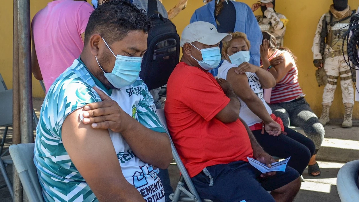  Varias personas migrantes reposan tras ser vacunados contra la Covid-19 hoy, en Tijuana, estado de Baja California (M&eacute;xico). Migrantes de Centroam&eacute;rica, Colombia, Hait&iacute; y de otras pa&iacute;ses que acampan en el cruce fronterizo de El Chaparral en la ciudad mexicana de Tijuana, recibieron este martes su primera dosis de la vacuna anticovid de la farmac&eacute;utica Pfizer