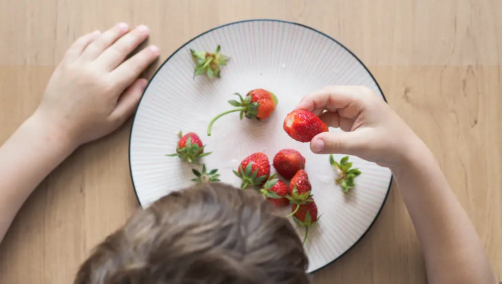 Niño comiendo fresas