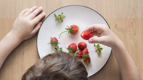 Niño comiendo fresas