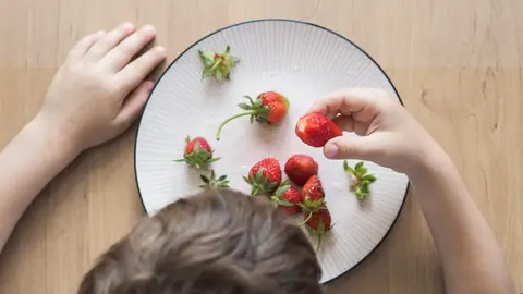 Niño comiendo fresas Niño comiendo fresas