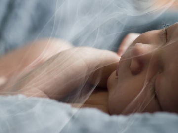 Un bebé respira el humo del tabaco