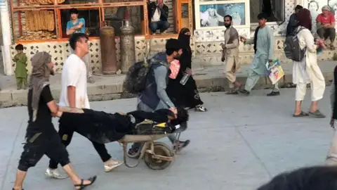 Varios afganos transportan a una de las vítimas de la explosión Varios afganos transportan a una de las vítimas de la explosión