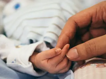 La mano de un bebé y la de una mujer. La mano de un bebé y la de una mujer.