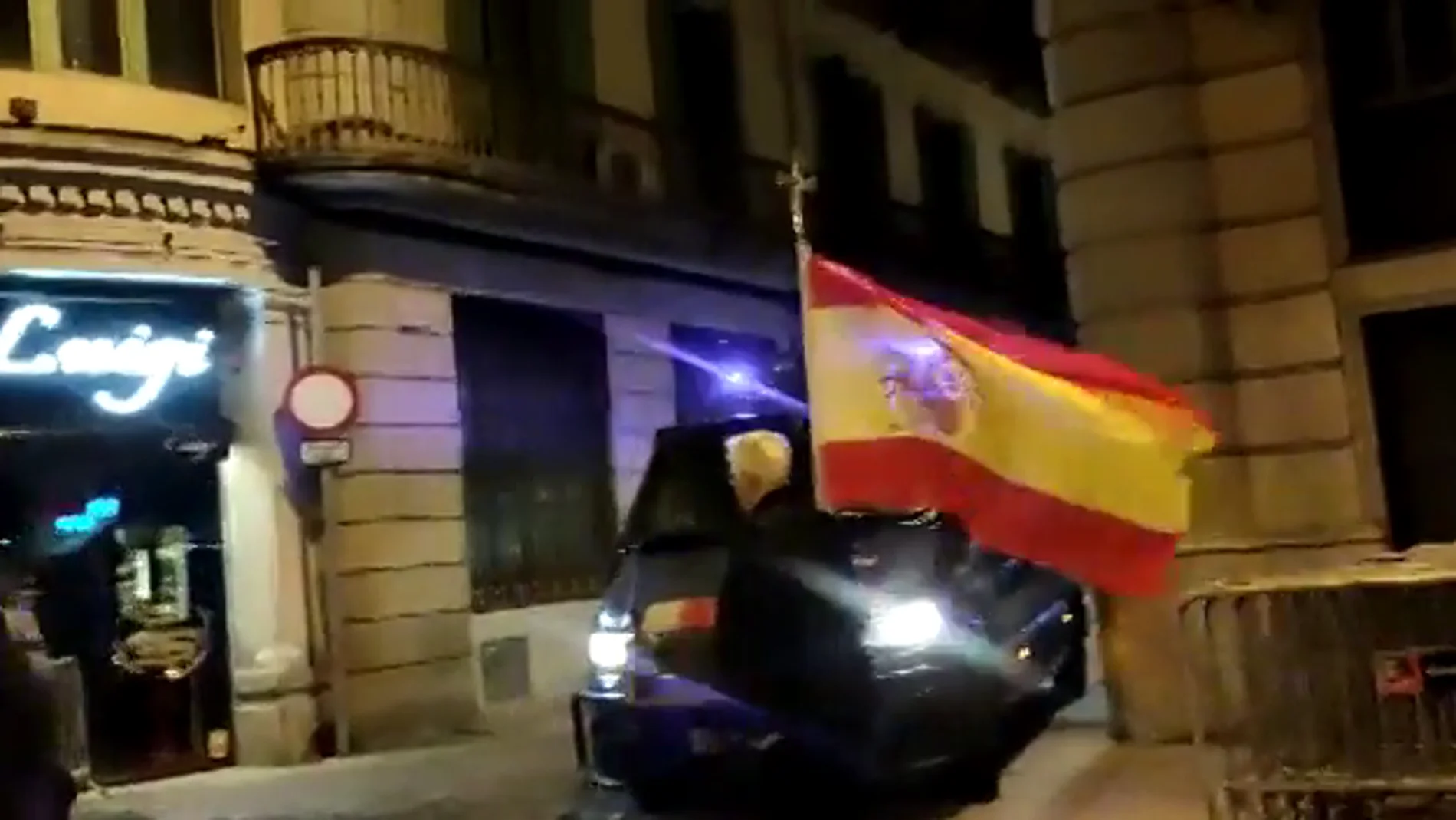 Un hombre se pasea por el centro de Barcelona con una bandera de España y un crucifijo tras el fin de la Diada