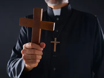 Sacerdote con un crucifijo. Sacerdote con un crucifijo.