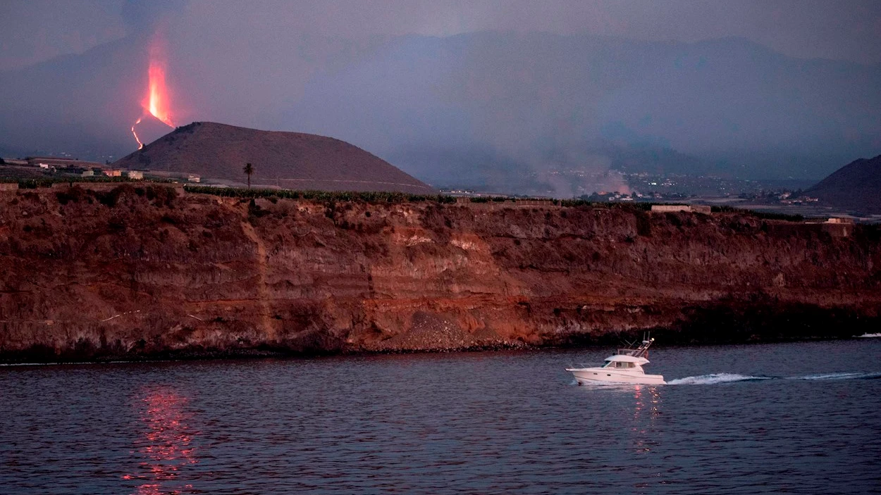 Una embarcaci&oacute;n de recreo regresa al atardecer al puerto de Tazacorte ubicado en la costa por donde se prev&eacute; llegue la lava del volc&aacute;n de Cumbre Vieja
