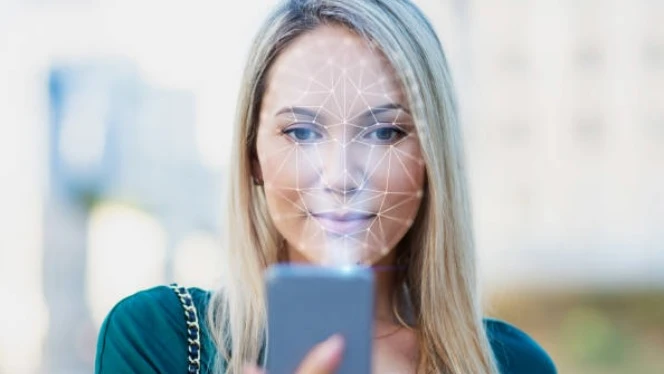 Foto de archivo de una mujer usando una app de reconocimiento facial Foto de archivo de una mujer usando una app de reconocimiento facial