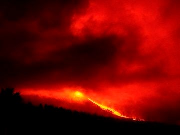 Vista esta madrugada de la erupción del volcán de La Palma y una de sus coladas de lava desde la localidad de Tajuya, en el municipio de El Paso