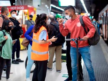 Una informadora atiende a un usuario de Renfe en uno de los andenes de la Estación de Sants de Barcelona este martes cuarto día de huelga de maquinistas