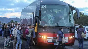 Cientos de personas se desplazan en los autobuses que las autoridades han dispuesto para acceder hasta la zona del volcán