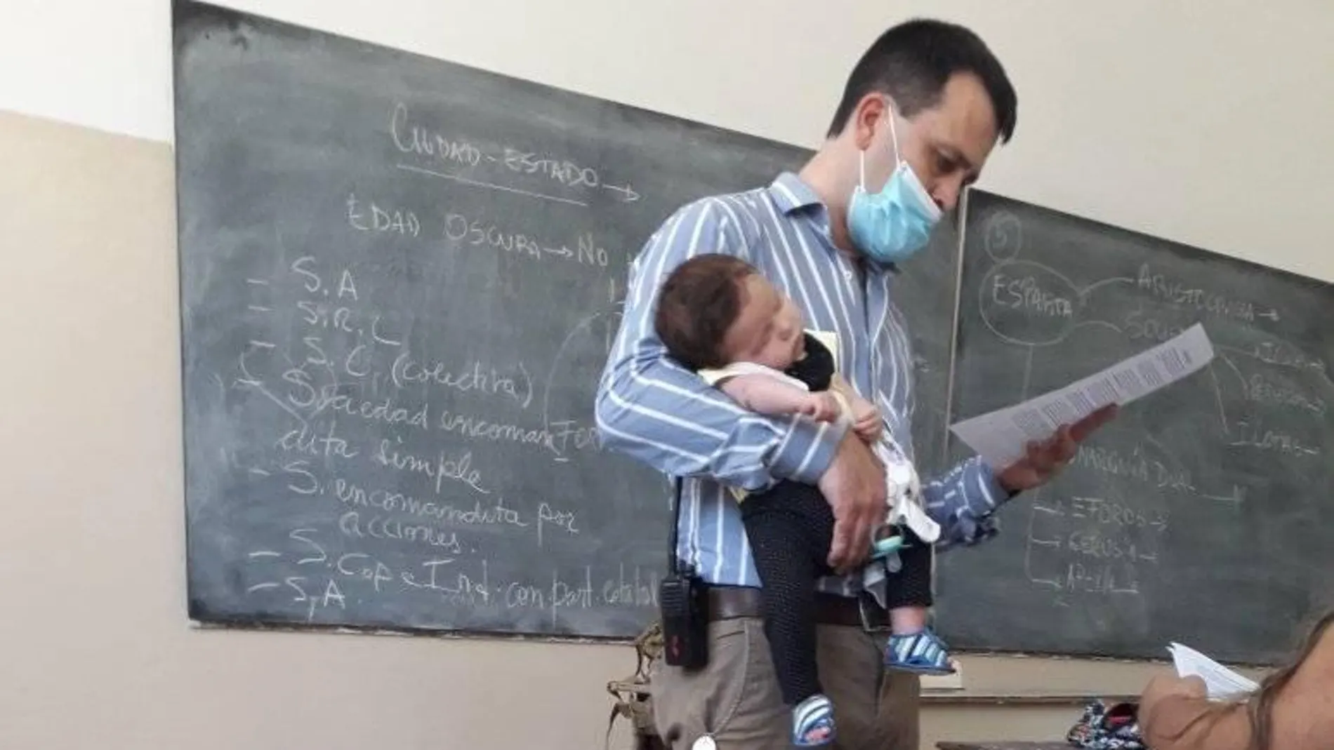 Un profesor cuida el bebé de una alumna para que pueda estudiar Un profesor cuida el bebé de una alumna para que pueda estudiar