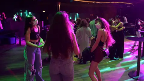 Gente con mascarilla en una discoteca Gente con mascarilla en una discoteca