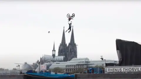 Luc Ackermann realiza un tsunami backflip con su moto saltando de un barco a otro sobre el río Rin Luc Ackermann realiza un tsunami backflip con su moto saltando de un barco a otro sobre el río Rin