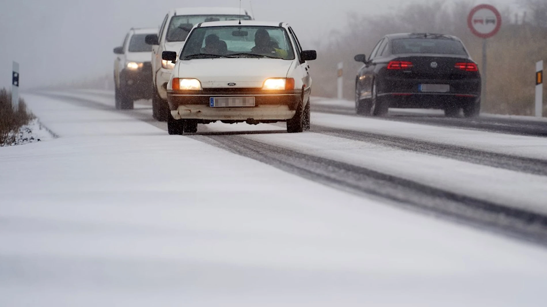 Vehículos circulan con dificultad por la carretera CL-505 en Ávila por la nieve caída en las últimas horas