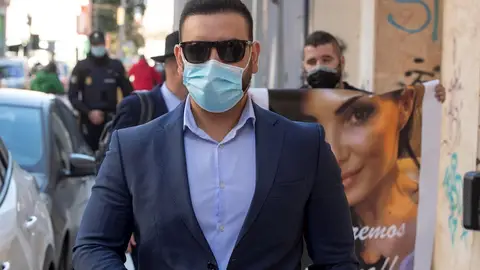 Un familiar (dcha, detrás) de la mujer de Alcantarilla (Murcia) de 39 años que murió un mes después de ser sometida a una lipoescultura en una clínica privada de Cartagena, muestra un retrato de la misma a la salida del cirujano Javier Alejandro Masso (delante) Un familiar (dcha, detrás) de la mujer de Alcantarilla (Murcia) de 39 años que murió un mes después de ser sometida a una lipoescultura en una clínica privada de Cartagena, muestra un retrato de la misma a la salida del cirujano Javier Alejandro Masso (delante)