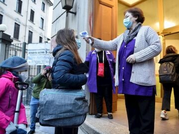 Una profesora toma la temperatura a una alumna en una imagen de archivo. 