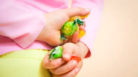 Niño escondiendo caramelos en su espalda. Niño escondiendo caramelos en su espalda.