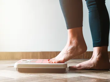 Mujer pesándose en una báscula. Mujer pesándose en una báscula.