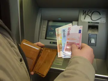 Imagen de archivo de una persona sacando dinero Imagen de archivo de una persona sacando dinero