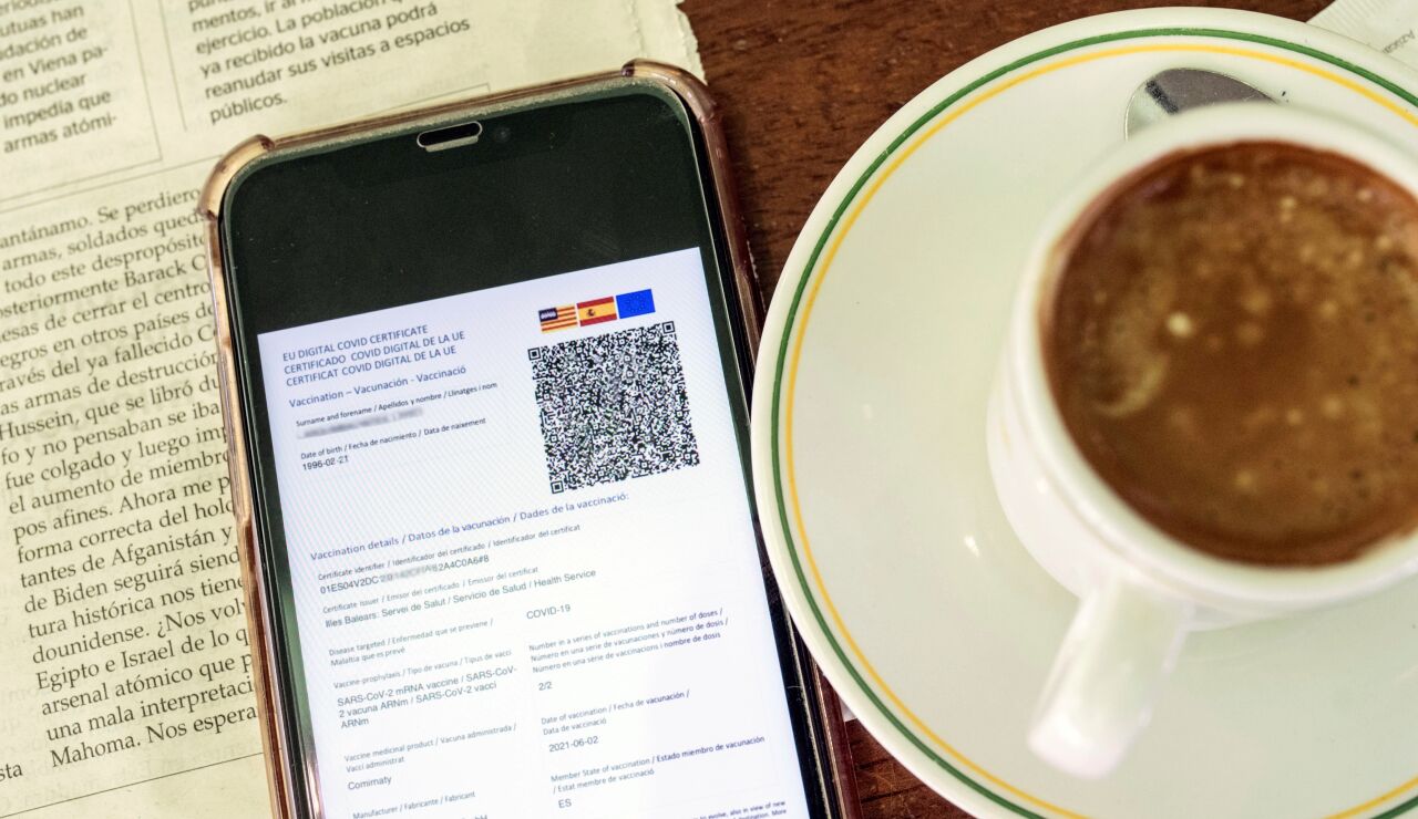 Detalle de un certificado covid en un smartphone en una cafetería