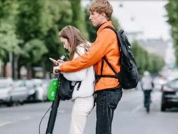 Dos jóvenes montados en un patinete eléctrico. Dos jóvenes montados en un patinete eléctrico.