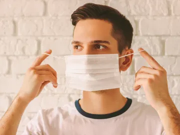 Un chico se pone la mascarilla quirúrgica. Un chico se pone la mascarilla quirúrgica.
