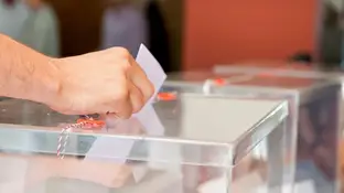 Foto de archivo de una persona introduciendo su voto en una urna electoral. Foto de archivo de una persona introduciendo su voto en una urna electoral.