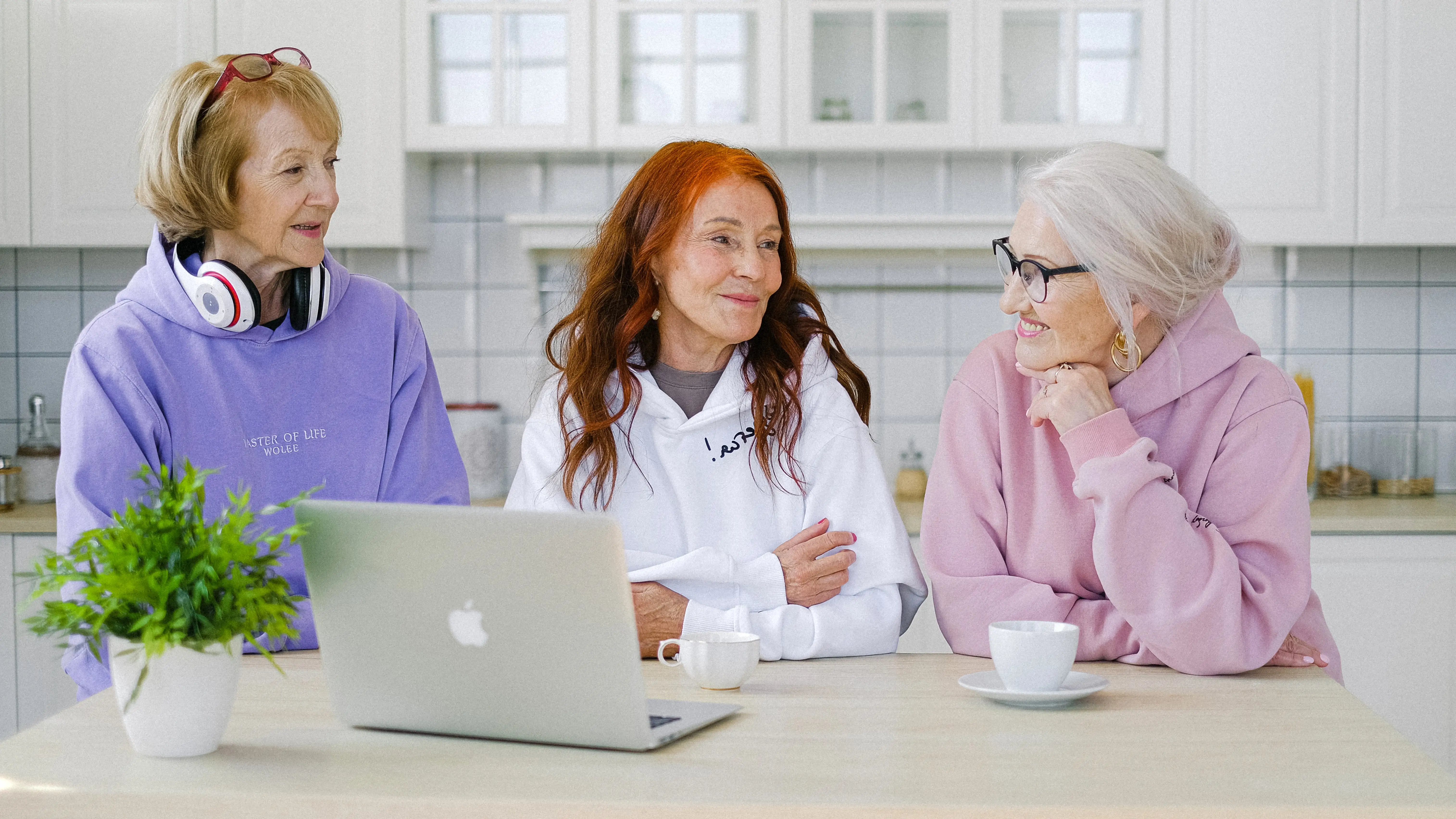 Tres mujeres conversan alrededor de un ordenador Tres mujeres conversan alrededor de un ordenador