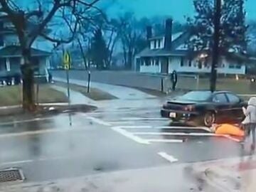 Momento en el que una policía evitar que atropellen a una estudiante.