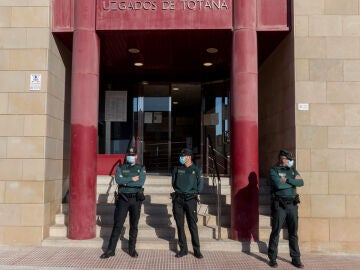 La guardia civil custodia la puerta principal de los juzgados de Totana, Murcia