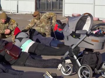 Jóvenes ucranianas entrenan en un campo de tiro junto a un carrito de bebé