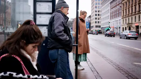 Varias personas esperan en una parada de autobús de Copenhague Varias personas esperan en una parada de autobús de Copenhague