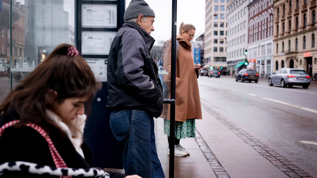 Varias personas esperan en una parada de autobús de Copenhague Varias personas esperan en una parada de autobús de Copenhague