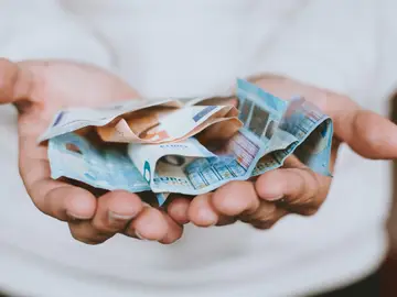 Foto de archivo de un hombre sosteniendo varios billetes de euro Foto de archivo de un hombre sosteniendo varios billetes de euro