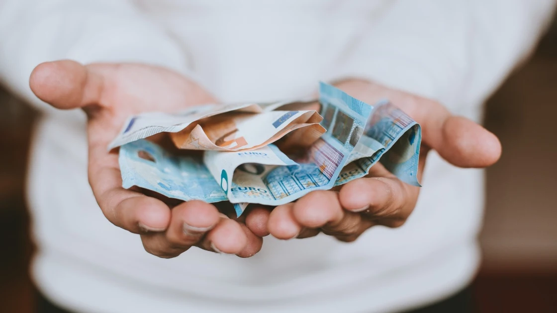 Foto de archivo de un hombre sosteniendo varios billetes de euro Foto de archivo de un hombre sosteniendo varios billetes de euro
