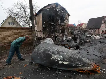 Un vecino de Kiev observa los restos de un avión derribado por el ejército ucraniano