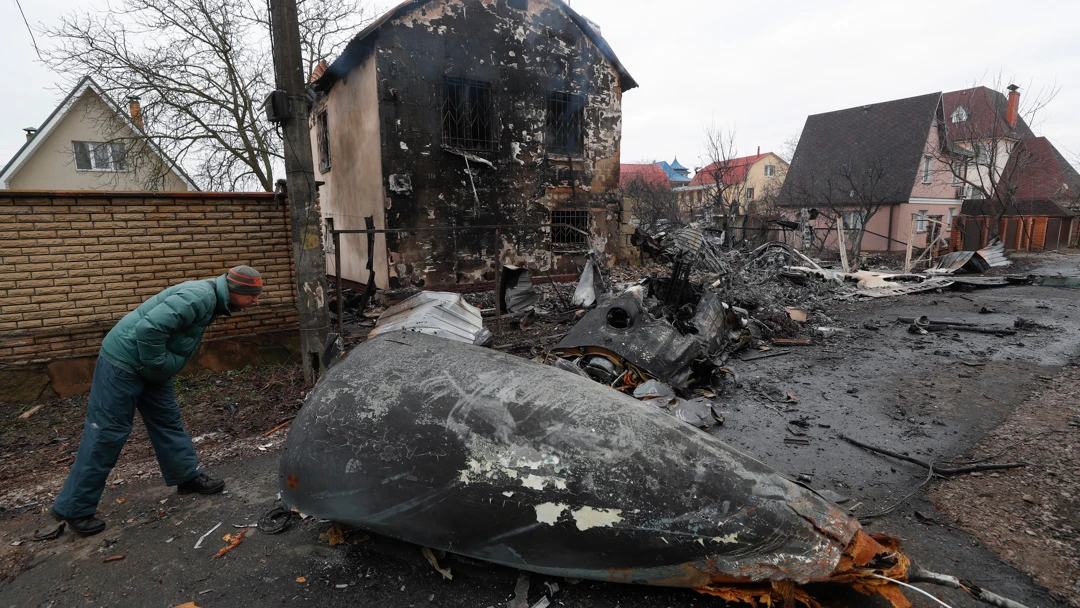 Un vecino de Kiev observa los restos de un avi&oacute;n derribado por el ej&eacute;rcito ucraniano