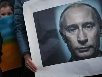 Una manifestante sostiene una pancarta con la imagen de Putin
