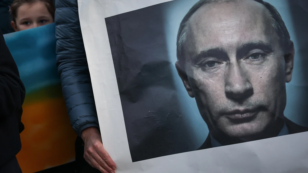 Una manifestante sostiene una pancarta con la imagen de Putin Una manifestante sostiene una pancarta con la imagen de Putin