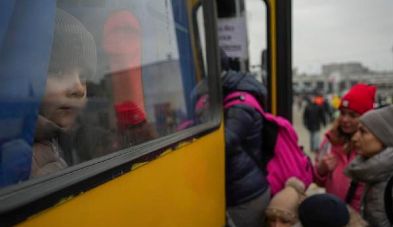 Niños y mujeres ucranianas subiendo a un autobús de refugiados