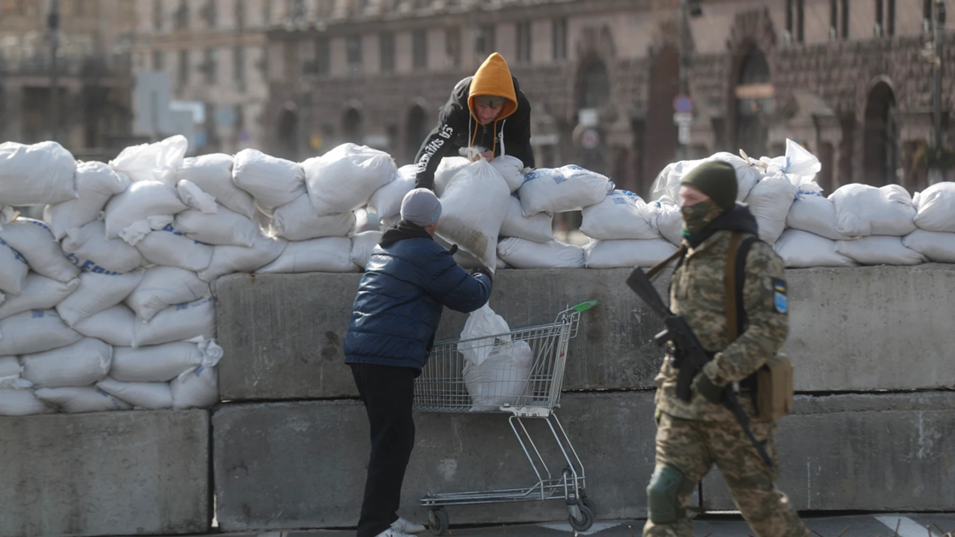 Dos jóvenes levantan un muro con sacos de arena en Kiev