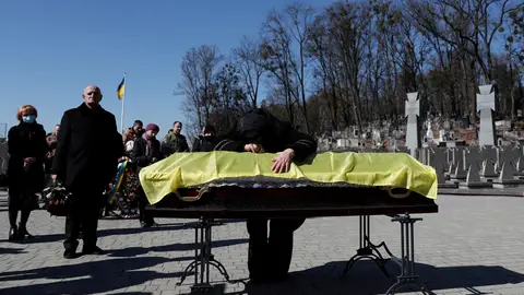 Una mujer llora junto al féretro de su hijo Una mujer llora junto al féretro de su hijo