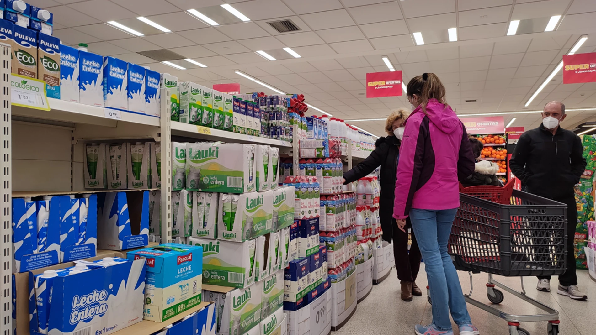 Varias personas compran leche en un supermercado de Madrid