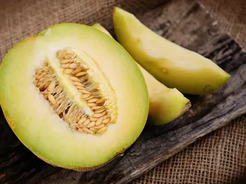 Imagen de una fruta, un melón cortado por la mitad y en rodajas Imagen de una fruta, un melón cortado por la mitad y en rodajas