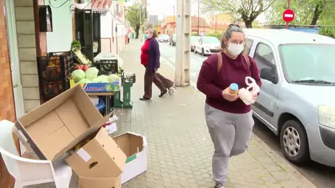 Consumidores en las calles de España, con una frutería al lado Consumidores en las calles de España, con una frutería al lado
