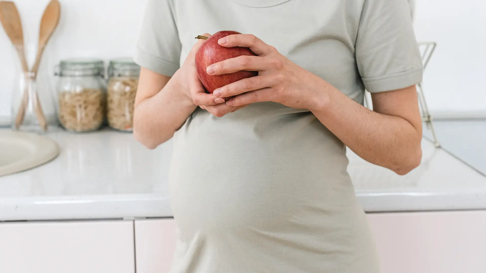 Mujer embarazada sujetando una manzana