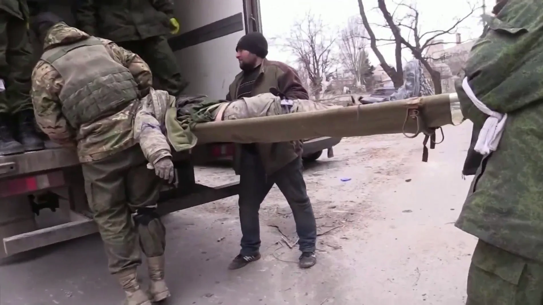 Soldados llevan un cadáver en la invasión rusa de Ucrania